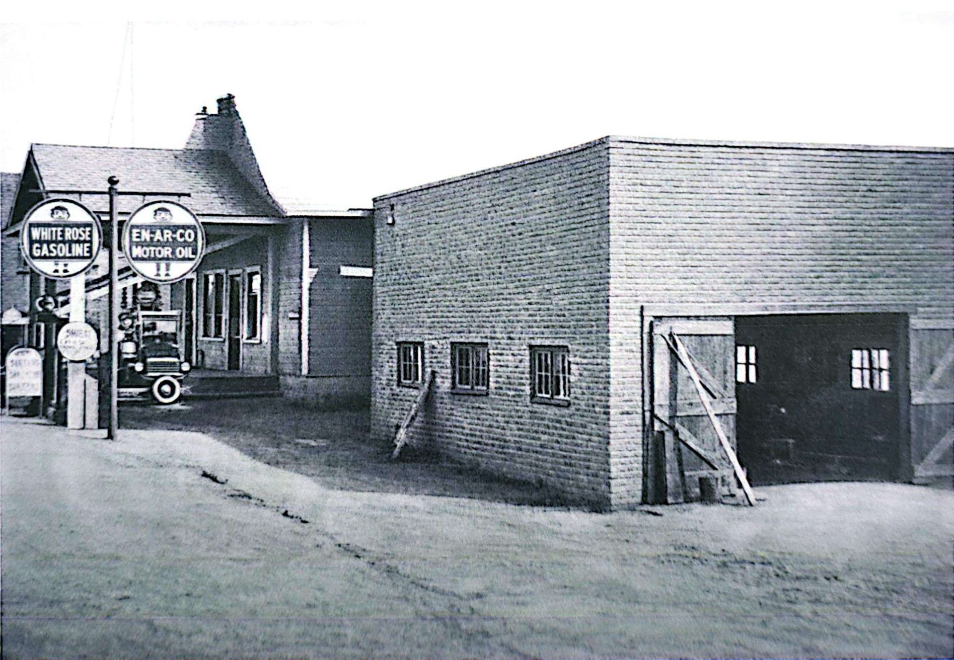 Acme Motors in Little Current circa 1947, showing the original garage with White Rose Gasoline and En-Ar-Co Motor Oil signs